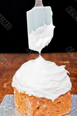 Spreading cream on cake icing Spreading cream on cake icing
