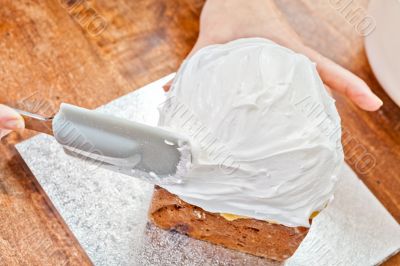 Spreading cream on cake with spatula Spreading cream on cake with spatula