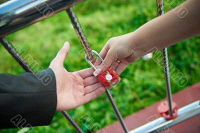 The bride and groom hold together their alliance lock