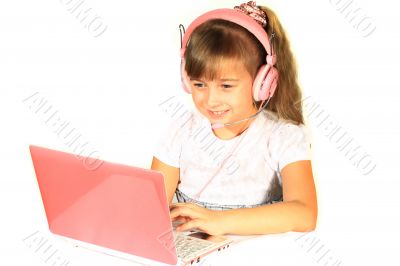 Beautiful little girl with headphones and a computer.