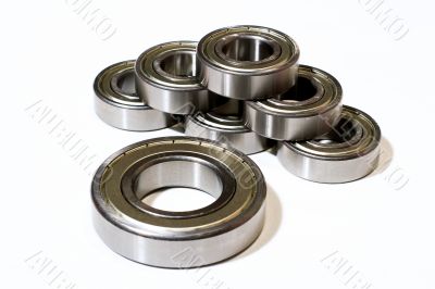 Many bearings of different sizes together. White background.