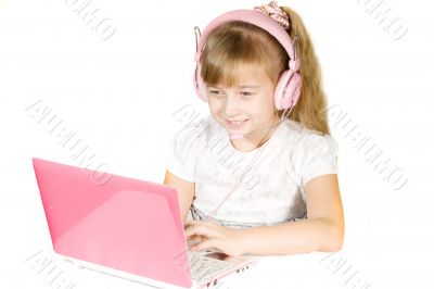 Beautiful little girl with headphones and a computer. 