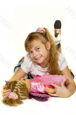 Beautiful little girl playing with a doll.