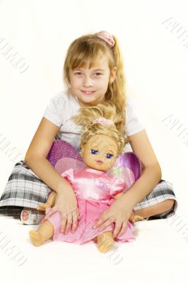 Beautiful little girl playing with a doll.