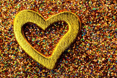 Gold shiny heart against the background of tinsel Gold shiny heart against the background of tinsel