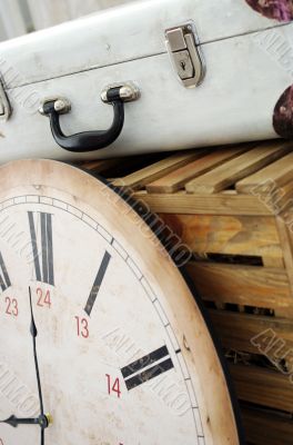 Vintage white suitcase on the box with clock