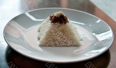 pyramid of rice on a plate in a restaurant with a worn table