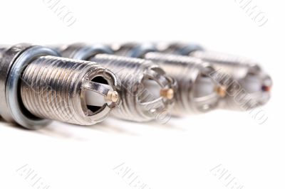 Four automobile spark plugs closeup