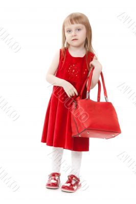 Fashion little girl with a red handbag, in catwalk model pose