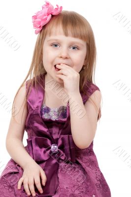 The little girl eats a candy. Isolated on a white background