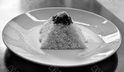 pyramid of rice on a plate in a restaurant with a worn table