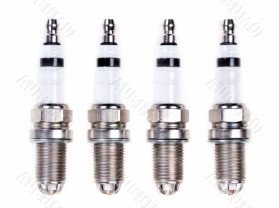 Four spark plugs. Isolated on white.