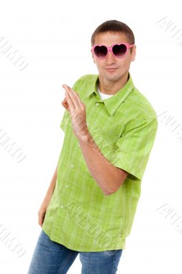Merry portrait of a young man in a ridiculous pink sunglasses