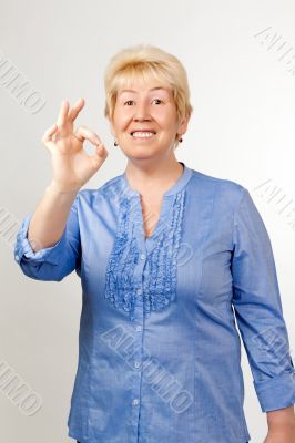 Middle-aged woman shows OK