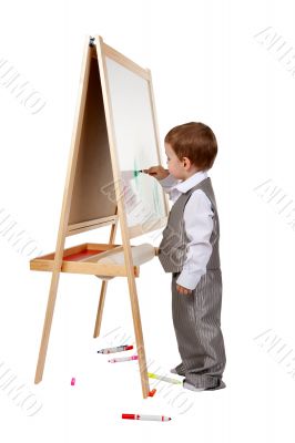 A child paints on an easel in the studio