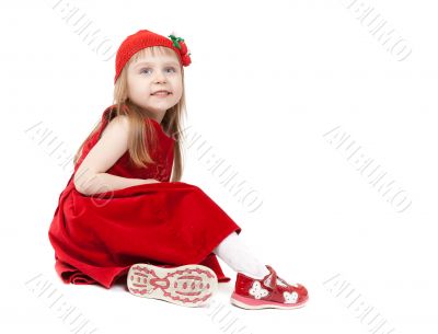 Beautiful four-year-old girl in a red dress and hat sitting on w