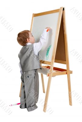 A child paints on an easel in the studio