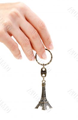 Hand holding small Eiffel Tower statuette