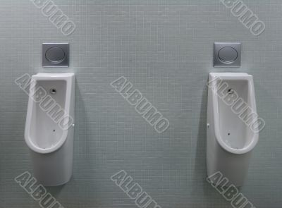 urinals with two white painted a fly on the toilet