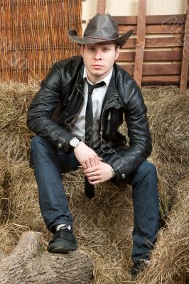 Handsome cowboy in leather jacket in the rural interior. Handsome cowboy in leather jacket in the rural interior.