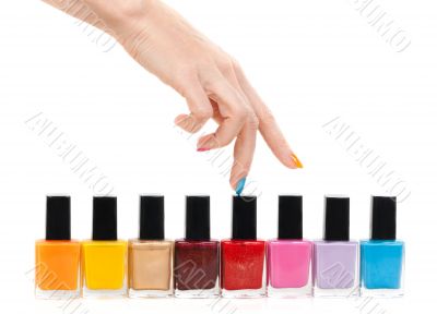 Female hand fingers are the colored paints polish on a white bac
