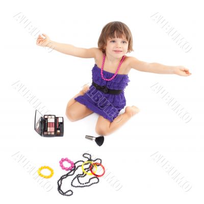Cute little girl with makeup, necklaces and bracelets is in adul