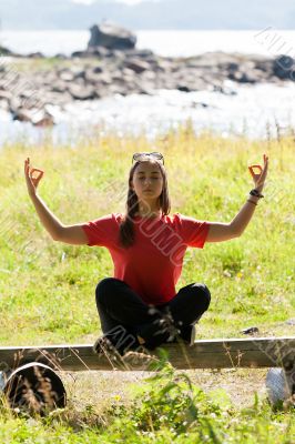 girl in a red dress sitting on a bench in the lotus position