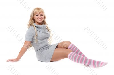 Young beautiful blonde in a striped socks sits on the floor in t