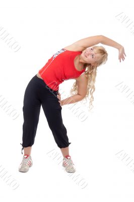 Beautiful girl in sportswear doing side bends.
