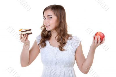 Young beautiful female choose from sweet cake and red apple