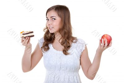 Young beautiful female choose from sweet cake and red apple Young beautiful female choose from sweet cake and red apple