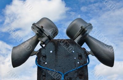 Outdoor public address loudspeakers against a blue sky