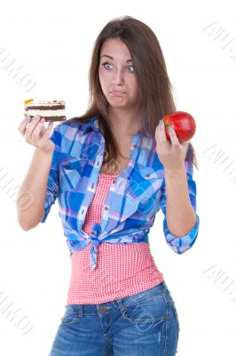 Girl in doubt with an apple and a cake