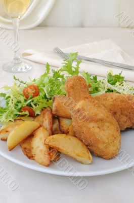 Chicken drumsticks with breadcrumbs with potatoes and salad