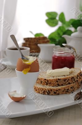 Breakfast with soft-boiled egg and slices of oatmeal bread