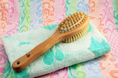 Wooden brush with the handle for massage of a body and a towel.