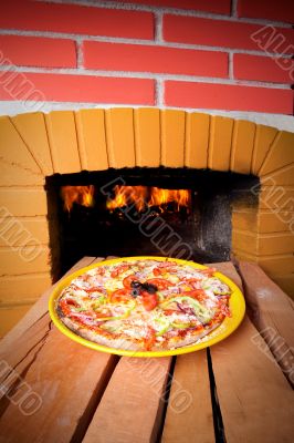 Pizza baking with wood fire in the oven 