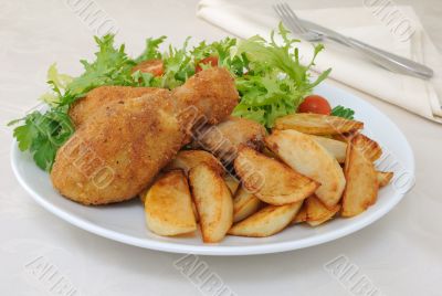 Chicken drumsticks with breadcrumbs with potatoes and salad