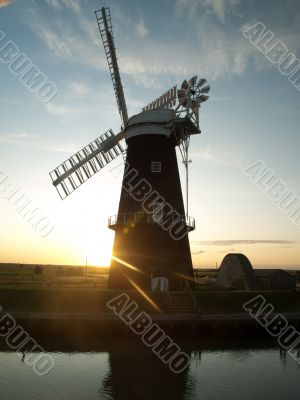 Sun setting behind windmill