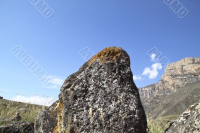 Stone on a background sky and mountains