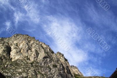 Bright blue sky and clouds above a mountain
