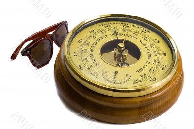 Barometer - aneroid on a white background and black sunglasses Barometer - aneroid on a white background and black sunglasses