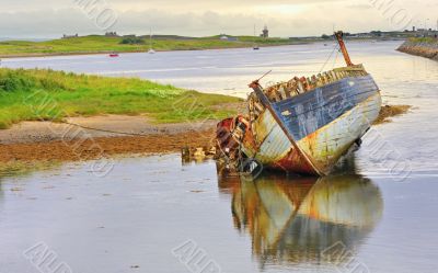 boat wreck lying on the shore of lake