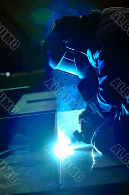 welder with protective mask welding metal 