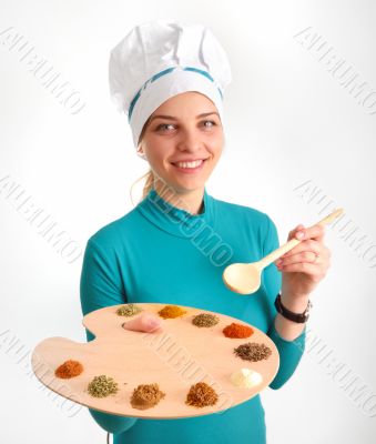 Spices and herbs on the palette and cook girl