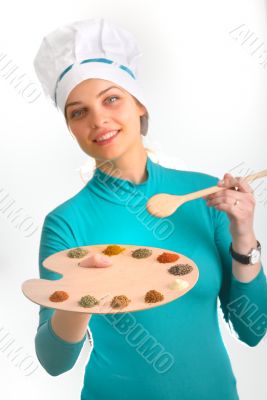 Spices and herbs on the palette and cook girl 