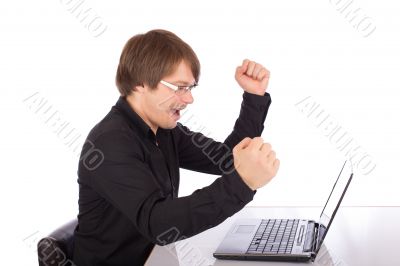 Business man raises arms in front of his laptop Business man raises arms in front of his laptop