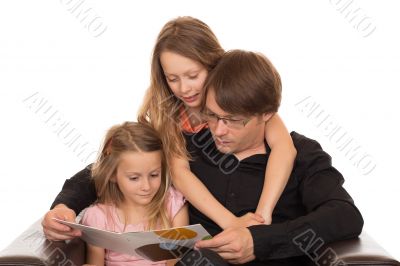 Father read a book with his â€‹â€‹daughters