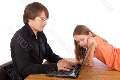 Daughter looks at her father`s laptop