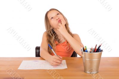 Child sitting at a table trying to make a drawing